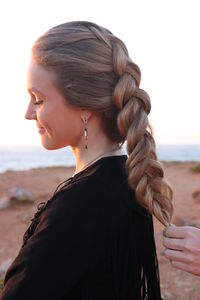 Portrait of woman on beach against sky