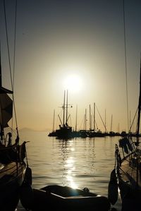 Boats in sea at sunset