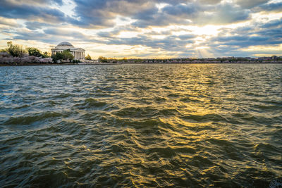 Scenic view of sea against cloudy sky during sunset