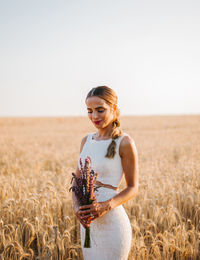 Bride standing by landscape against clear sky