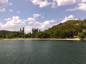 Scenic view of sea and trees against sky