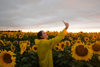Full length of sunflowers on sunflower field against sky