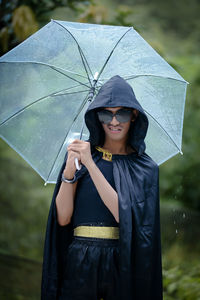 Portrait of young woman holding umbrella