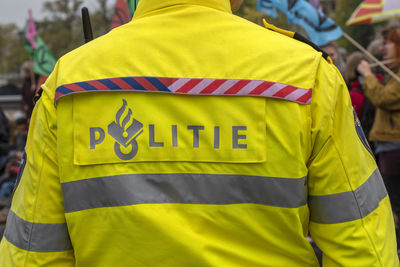 Rear view of man standing against yellow flag