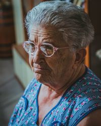 Close-up of thoughtful senior woman wearing eyeglasses at home