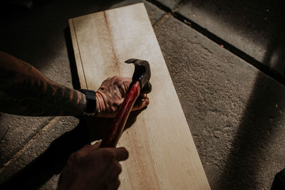 Overhead shot of man hammering a nail into board