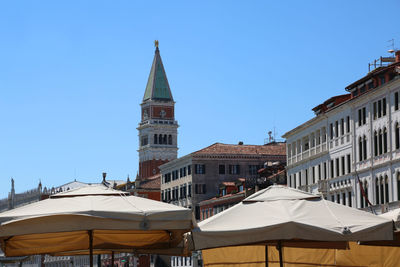 Bell tower of san marco in venice in italy with the stalls of the local market