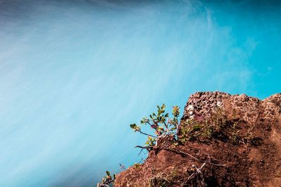 High angle view of rock by sea against sky