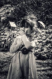 Girl holding umbrella on field