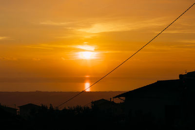 Scenic view of silhouette landscape against orange sky