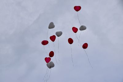 Low angle view of balloons flying against sky