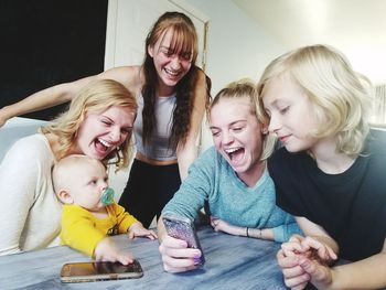 Happy siblings playing with baby at home