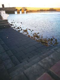 Surface level of footpath by lake against sky