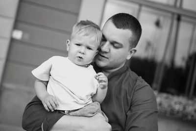 Father holding his baby boy tenderly. loving father and son