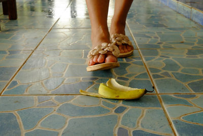 Low section of woman walking on tiled floor