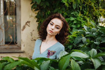 Portrait of beautiful teenage girl standing amidst plants