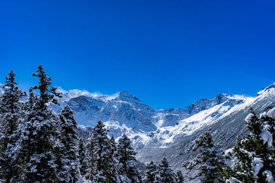 Scenic view of snowcapped mountains against blue sky