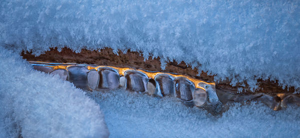 Aerial view of river flowing amidst snow covered ice