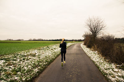 Full length of running on footpath against trees