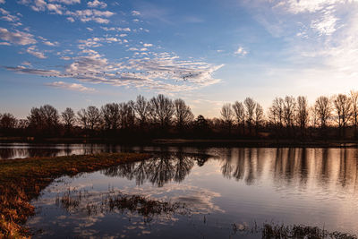 Scenic view of lake against sky at sunset