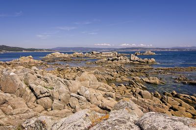 Scenic view of beach against blue sky