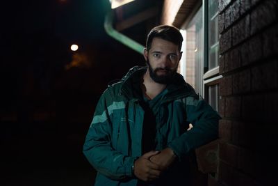 Portrait of young man standing at night