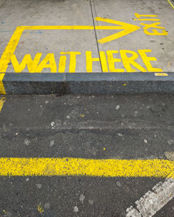 High angle view of yellow sign on road