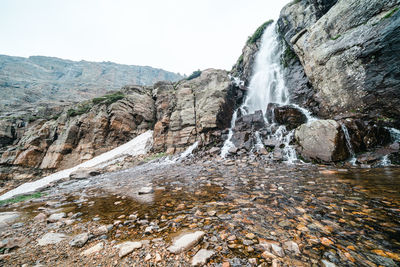 Scenic view of waterfall against sky