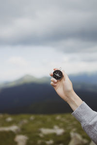 Cropped hand of man holding camera