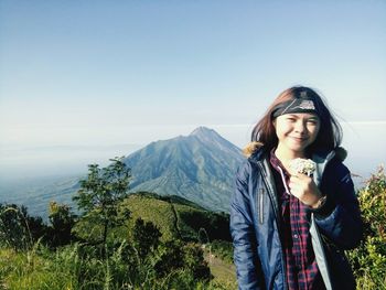 Portrait of woman standing on mountain against clear sky