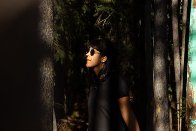 Portrait of young woman standing against wall