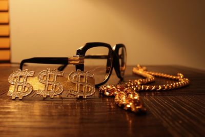 Close-up of jewelries and eyeglasses on wooden table