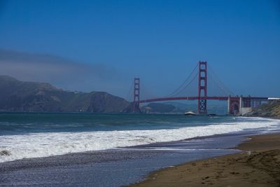 Golden gate bridge over sea against clear blue sky