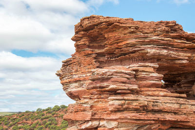 Low angle view of rock formation against cloudy sky