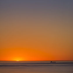 Scenic view of sea against clear sky during sunset