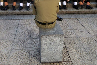 Low section of woman standing on sidewalk